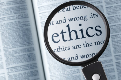 Magnifying glass on the"ethics" in dictionary